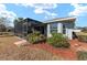 Exterior view of home featuring a screened in lanai, backyard, and landscaping at 4987 Belted Kingfisher Dr, Oxford, FL 34484