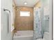 Bathtub and shower combo with tiled walls and a window for natural light at 4987 Belted Kingfisher Dr, Oxford, FL 34484