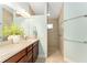 Bathroom featuring a double vanity and a tiled walk-in shower at 4987 Belted Kingfisher Dr, Oxford, FL 34484