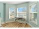 A charming bedroom with hardwood floors and lots of natural light from three separate windows at 4987 Belted Kingfisher Dr, Oxford, FL 34484