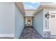 Pathway leads to a welcoming front door with decorative wreath and stylish exterior lighting at 4987 Belted Kingfisher Dr, Oxford, FL 34484
