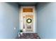 Close-up of the front door with decorative wreath and sidelights, creating a warm and inviting entrance at 4987 Belted Kingfisher Dr, Oxford, FL 34484