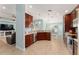 Modern kitchen with dark wood cabinets, stainless steel appliances, and open view to the dining area at 4987 Belted Kingfisher Dr, Oxford, FL 34484