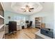 Bright home office featuring hardwood floors, a ceiling fan, and two desk setups at 4987 Belted Kingfisher Dr, Oxford, FL 34484