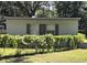 The back side of house featuring two windows with green shutters and fence with ivy at 504 Se 35Th Ave, Ocala, FL 34471