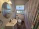 Bathroom with a sink and vanity, toilet, and flamingo-themed shower curtain and window at 504 Se 35Th Ave, Ocala, FL 34471