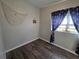 A well-lit bedroom featuring dark blue curtains with an anchor print and modern wood-look flooring at 504 Se 35Th Ave, Ocala, FL 34471