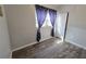 A bedroom space with wood floor, window with a curtain, and a white door at 504 Se 35Th Ave, Ocala, FL 34471