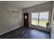 Bright entryway featuring dark wood-look floors, front door, and nautical decor at 504 Se 35Th Ave, Ocala, FL 34471