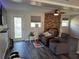 Cozy living room with dark wood-look floors, brick fireplace, and comfortable seating at 504 Se 35Th Ave, Ocala, FL 34471