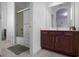Bright bathroom boasts a shower/tub combo with sliding glass doors and a modern dark-wood vanity with ample storage at 5241 Oakbourne Ave, Davenport, FL 33837