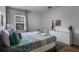 Serene bedroom with a queen bed, a crib, and a light-colored dresser providing a comfortable and functional space at 5241 Oakbourne Ave, Davenport, FL 33837