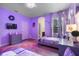 Whimsical bedroom featuring playful violet walls, a bed with sheer curtains, and enchanting princess-themed decorations at 5241 Oakbourne Ave, Davenport, FL 33837