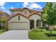 Charming two-story home features a well-manicured lawn, tile roof, and a two-car garage at 5241 Oakbourne Ave, Davenport, FL 33837