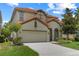 Charming two-story home features a well-manicured lawn, tile roof, and a two-car garage at 5241 Oakbourne Ave, Davenport, FL 33837