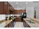 Modern kitchen with dark wood cabinets, granite countertops, and stainless steel appliances at 5241 Oakbourne Ave, Davenport, FL 33837