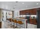 Modern kitchen with dark wood cabinets, granite countertops, breakfast bar, and stainless appliances at 5241 Oakbourne Ave, Davenport, FL 33837