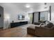 Bright living room featuring modern furnishings, wood floors, and large sectional sofa at 5241 Oakbourne Ave, Davenport, FL 33837