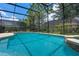 A private screened-in pool surrounded by lush greenery offers a serene and refreshing escape at 5241 Oakbourne Ave, Davenport, FL 33837