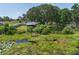 Aerial shot showcases the home's expansive lot, lush greenery, and serene pond at 5380 County Road 122, Wildwood, FL 34785