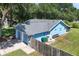 A view of the back of the home, a well maintained yard, wooden fence, bench, and two-car garage at 5380 County Road 122, Wildwood, FL 34785