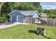 A view of the back of the home with lovely landscaped yard, a wooden fence, and well at 5380 County Road 122, Wildwood, FL 34785