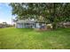The large backyard features a screened-in porch, outdoor bar, and mature trees that offer plenty of shade at 5380 County Road 122, Wildwood, FL 34785