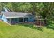 Spacious backyard includes a screened patio, outdoor bar, and lush green grass, perfect for entertaining at 5380 County Road 122, Wildwood, FL 34785