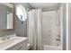 Bathroom with a modern shower and a unique, eye-catching octagonal window with white marble sink and grey walls at 5380 County Road 122, Wildwood, FL 34785