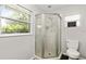 Bathroom featuring a corner shower, white toilet, and windows looking to the backyard at 5380 County Road 122, Wildwood, FL 34785