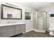 Bathroom featuring gray vanity with marble counter, a corner shower, wood-look tile floor and an exterior window at 5380 County Road 122, Wildwood, FL 34785