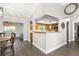 View of dining room showing kitchen access, hardwood floors, and natural light at 5380 County Road 122, Wildwood, FL 34785