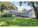 Charming one-story home with well-maintained lawn, blue siding, and attached two-car garage at 5380 County Road 122, Wildwood, FL 34785
