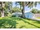 Inviting home exterior showcasing lush lawn, mature trees, and a two-car garage at 5380 County Road 122, Wildwood, FL 34785