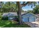 Charming blue house with an attached two-car garage and a covered porch at 5380 County Road 122, Wildwood, FL 34785