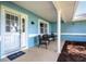 Cozy covered front porch with comfortable seating, columns, and a storm door at 5380 County Road 122, Wildwood, FL 34785