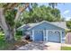 Charming blue house with an attached two-car garage and mature trees at 5380 County Road 122, Wildwood, FL 34785