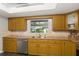 Bright kitchen with granite countertops, stainless steel dishwasher, and wood-look flooring at 5380 County Road 122, Wildwood, FL 34785