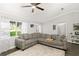 Spacious living room with comfortable gray sofa, rug, and large windows at 5380 County Road 122, Wildwood, FL 34785