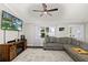 Bright living room featuring a comfortable gray sofa, dark floors, and large windows at 5380 County Road 122, Wildwood, FL 34785