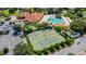 Aerial view of community featuring tennis courts, a pool, and clubhouse amidst lush greenery at 5437 Compass Pt # 00, Oxford, FL 34484