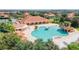 Aerial view of a large community pool featuring a waterfall, island feature, and lounge chairs at 5437 Compass Pt # 00, Oxford, FL 34484