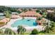 Aerial view of a community pool with a waterfall, rock features, lounge chairs, and lush landscaping at 5437 Compass Pt # 00, Oxford, FL 34484