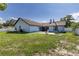 Home's exterior view of the backyard featuring a basketball hoop, white fencing and a spacious grassy area at 5521 Oak St, Mount Dora, FL 32757