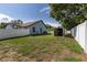 Wide backyard featuring a storage shed, white fencing and lush green grass at 5521 Oak St, Mount Dora, FL 32757