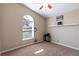 Bright bedroom featuring neutral walls, carpet flooring, a ceiling fan, and a large arched window at 5521 Oak St, Mount Dora, FL 32757