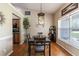 Bright dining room with modern light fixture, wood floors, and natural light from a large window at 5521 Oak St, Mount Dora, FL 32757