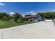 Beautiful single-story home with blue exterior and manicured lawn with large paved driveway at 5521 Oak St, Mount Dora, FL 32757