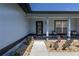 Charming front porch featuring stylish décor, a glass front door, and manicured landscaping at 5521 Oak St, Mount Dora, FL 32757