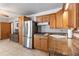 Cozy kitchen with wood cabinetry, stainless steel refrigerator, and granite countertops at 5521 Oak St, Mount Dora, FL 32757